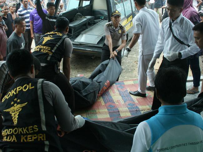 Indonesian police unload the bodies of victims after a boat carrying nearly 100 suspected migrant workers capsized and sunk in Indonesian waters off Batam on November 2, 2016. At least 18 people are dead and dozens missing after a boat carrying nearly 100 suspected migrant workers capsized and sunk in Indonesian waters, police said on November 2. / AFP PHOTO / SEI LATIFA