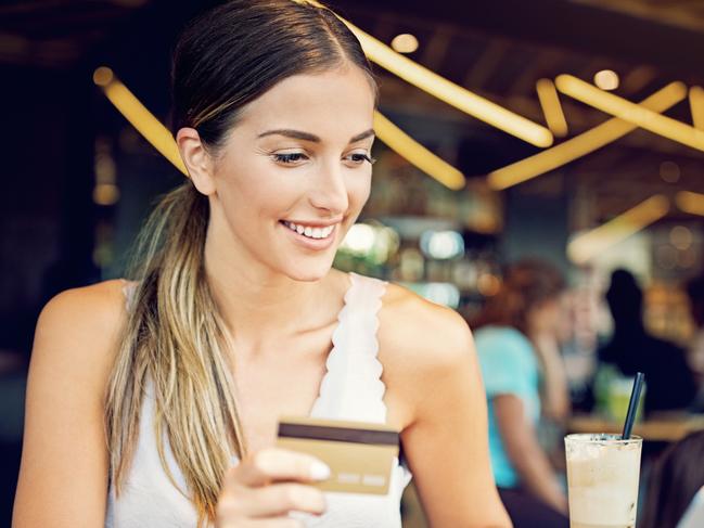 Young girl is shopping online in the cafe using laptop and her credit card