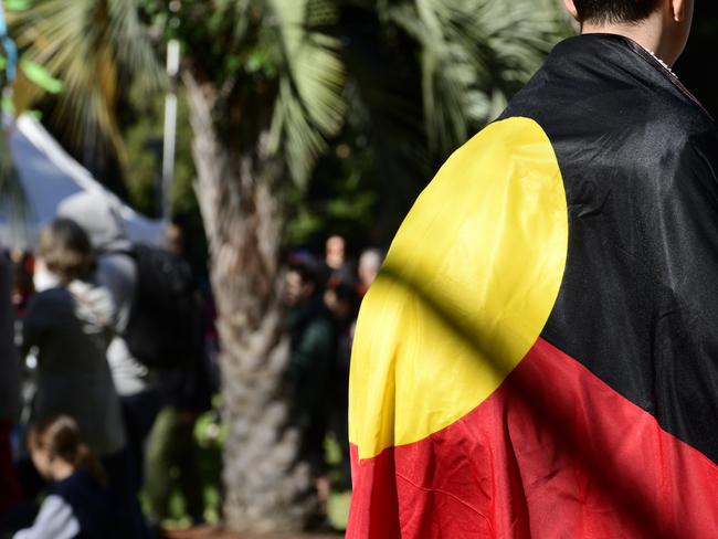 A member of the public is seen with the Aboriginal flag during the City of Sydney's annual NAIDOC in the City event in Hyde Park on Saturday, July 13. Picture: AAP Image/Bianca De Marchi