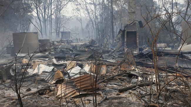 The ruins of a house smoulders on Old Bar road near Taree. Picture: AAP