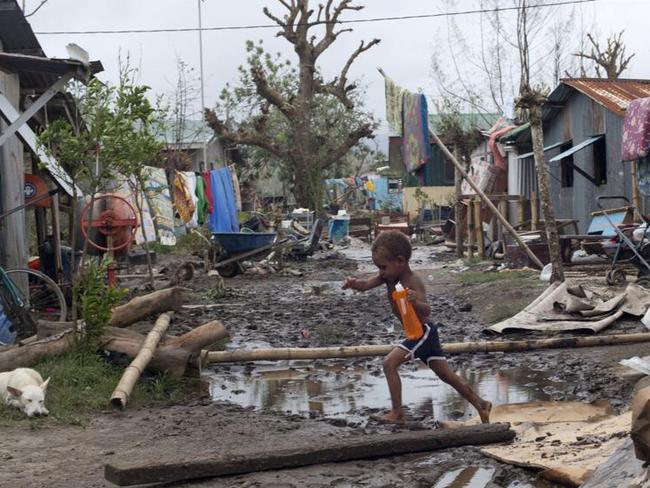 Young children play around debris as residents begin to clean up after Cyclone Pam in Mele village, on the outskirts of the capital Port Vila, Vanuatu