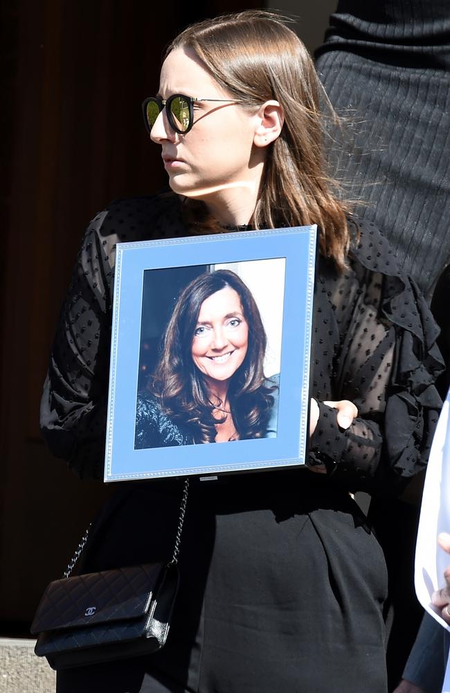 Sarah Ristevski exits the funeral service for her mum Karen with a photograph of her. At the time, her father Borce was a suspect in Karen’s killing but had not been arrested. Picture: Nicole Garmston