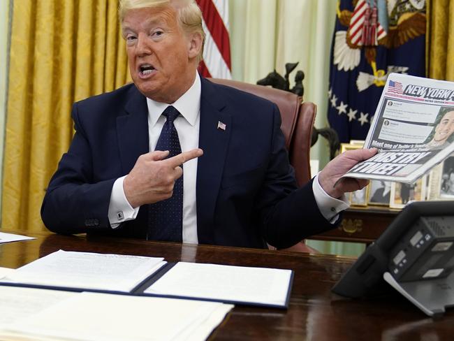 President Donald Trump holds up a copy of the New York Post. Picture: AP