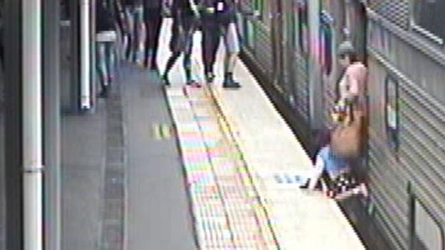 The child quickly falls from the woman’s grip. Picture: Sydney Trains