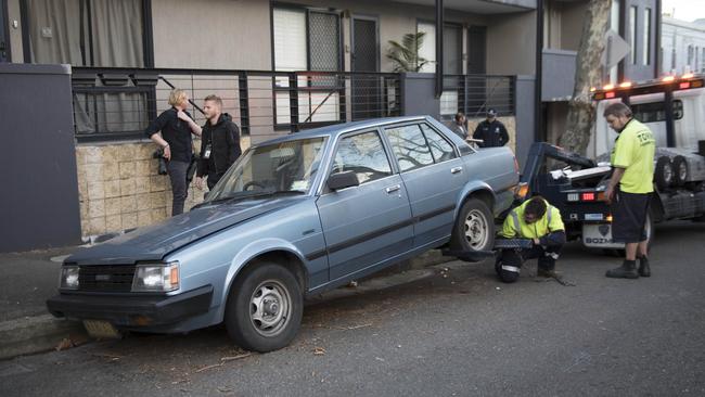 Police officers collect evidence as they prepare to remove two vehicles from Wilton St, Surry Hills. Picture: Darren Leigh Roberts