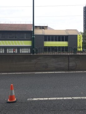 The car skidded into the side of the tram stop barrier, grazing the concrete.