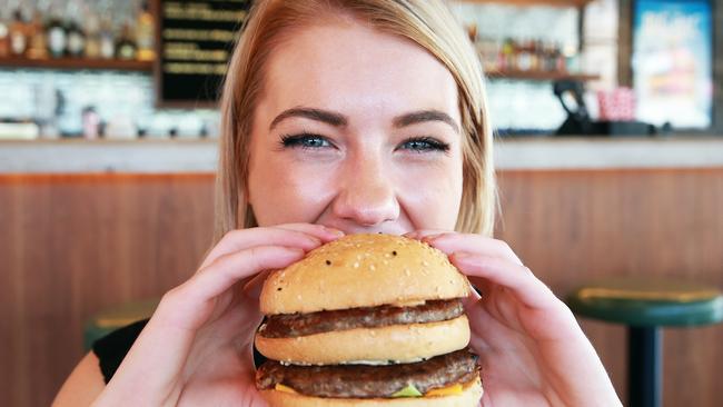 Ailish Harding poses with a Big Pac burger at Burger Urge in Windsor, Brisbane on Wednesday, November 14, 2018. McDonalds have issued a cease and desist letter to the burger business. (AAP Image/Claudia Baxter)