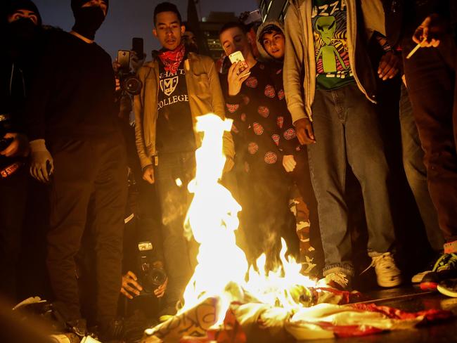 NEW YORK, NY - NOVEMBER 9: Protestors burn an American flag on Fifth Avenue outside of Trump Tower, November 9, 2016 in New York City. Republican candidate Donald Trump won the 2016 presidential election in the early hours of the morning in a widely unforeseen upset. Drew Angerer/Getty Images/AFP == FOR NEWSPAPERS, INTERNET, TELCOS & TELEVISION USE ONLY ==