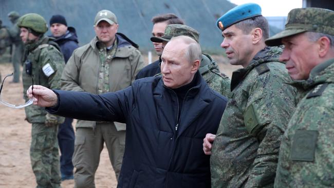 Vladimir Putin (C) meets soldiers during a visit at a military training centre. Picture: AFP.