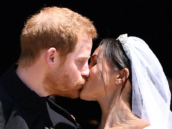 (FILES) In this file photo taken on May 19, 2018 Britain's Prince Harry, Duke of Sussex kisses his wife Meghan, Duchess of Sussex as they leave from the West Door of St George's Chapel, Windsor Castle, in Windsor, on May 19, 2018 after their wedding ceremony. - Meghan Markle has revealed she suffered a miscarriage in July this year, writing in the New York Times on November 25, 2020 of the deep grief and loss she endured with her husband Prince Harry. (Photo by Ben STANSALL / POOL / AFP)