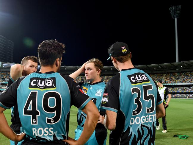 Brisbane Heat players at the Gabba on Thursday night with the affected light tower in the background. Picture: AAP 