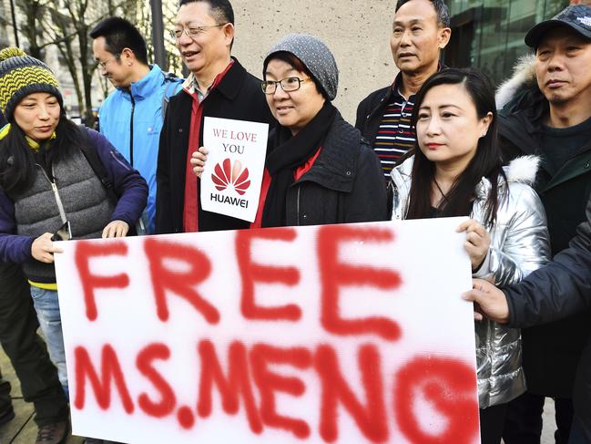 People hold a sign at a Vancouver, British Columbia courthouse prior to the bail hearing for Meng Wanzhou, Huawei's chief financial officer on Monday, December 10, 2018. (Jonathan Hayward/The Canadian Press via AP)