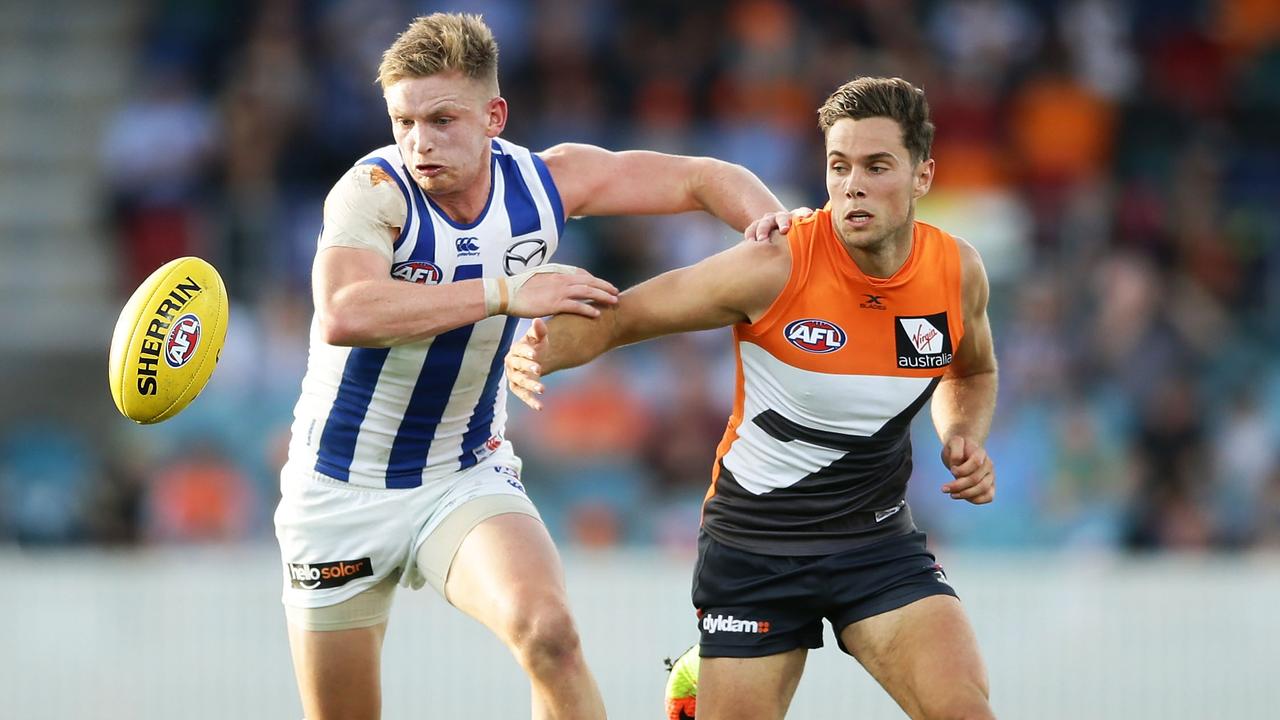 North Melbourne captain and Josh Kelly fight for a ball.