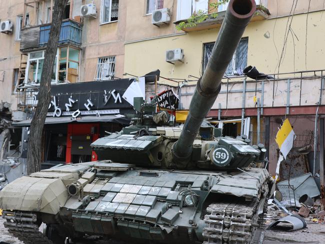 MARIUPOL, UKRAINE - MAY 04: A tank is seen in front of the damaged building as Russian attacks continue in Mariupol, Ukraine on May 04, 2022. Residents of Mariupol at this time are trying to survive on their own and in evacuation camps. (Photo by Leon Klein/Anadolu Agency via Getty Images)