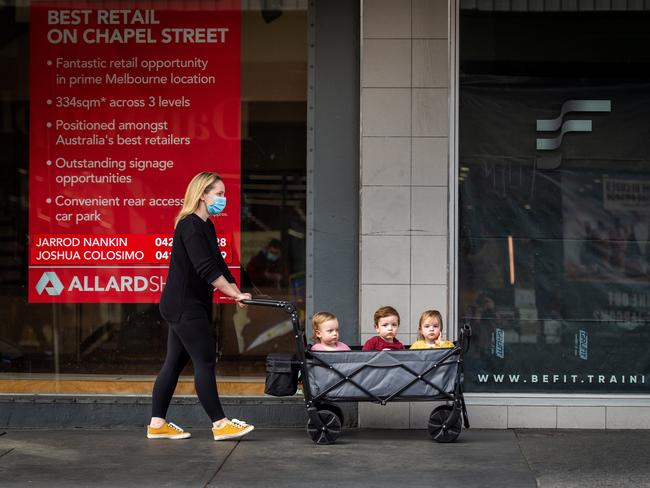 Daniella Altit walks her 19 month old triplets Jackson, Amelie and Mia in a foldable beach trolley down Chapel Street. Picture: Jake Nowakowski