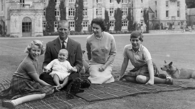 Queen Elizabeth II and Prince Philip, Duke of Edinburgh with their children, Prince Andrew (centre), Princess Anne (left) and Charles, Prince of Wales sitting on a picnic rug outside Balmoral Castle in Scotland in 1960.