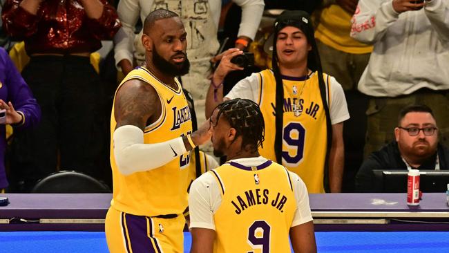 Los Angeles Lakers' US small forward #23 LeBron James (L) and Los Angeles Lakers' US guard #09 Bronny James are seen on court during the NBA game season opener between the Los Angeles Lakers and the Minnesota Timberwolves at Crypto Arena in Los Angeles on October 22, 2024. LeBron and Bronny are the first father and son to play together in any NBA game. (Photo by Frederic J. Brown / AFP)