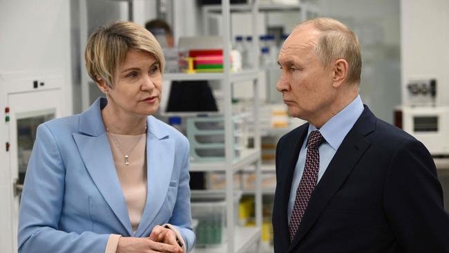 Russian President Vladimir Putin speaks with a head of the educational foundation Sirius Elena Shmeleva, as they visit lab facilities (Photo by Vladimir Astapkovich and Vladimir ASTAPKOVICH / SPUTNIK / AFP)