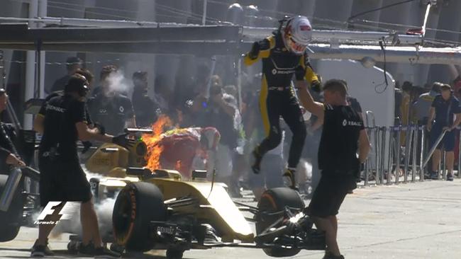 Magnussen leaps from his car as it catches fire.