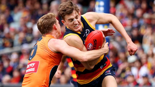 Lachie Whitfield, tackling Crow Lachlan Gollant, booted three goals. Picture: James Elsby/AFL Photos