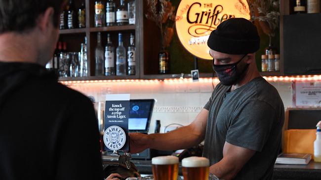 A bartender pours beer for his customers at a Sydney pub after the easing of lockdown restrictions. Picture: AFP