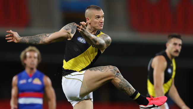 Dustin Martin of the Tigers kicks long inside 50 . Pic: Michael Klein