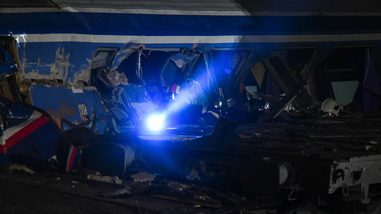 Firefighters and rescuers work to free passengers from a railroad car after a rail accident involving a collision between a cargo and a passenger train in the Evangelismos area of Larissa, Greece. Picture: Stringer/SOON/SOON via AFP