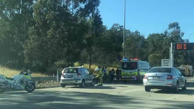 Paramedics treat the drivers of a two car crash at Helensvale on the M1.