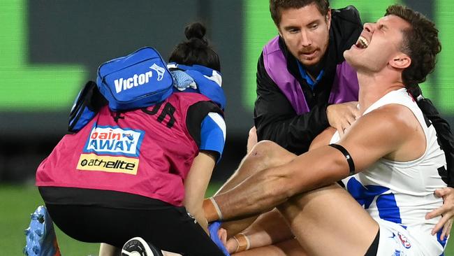 MELBOURNE, AUSTRALIA - APRIL 29: Charlie Comben of the Kangaroos is attended to by trainers during the round seven AFL match between Melbourne Demons and North Melbourne Kangaroos at Melbourne Cricket Ground, on April 29, 2023, in Melbourne, Australia. (Photo by Quinn Rooney/Getty Images)