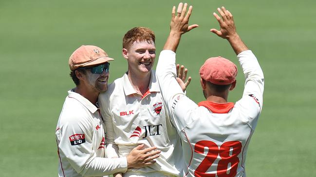 Andrews (centre) reacts with Travis Head (left) and Jake Weatherald (right) after taking a wicket. Picture: AAP/DAVE HUNT