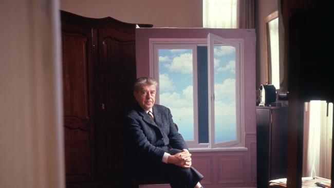 The master of deception sits with his painting ‘The telescope (Le téléscope)’ 1963.