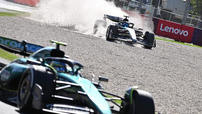 Mercedes' British driver George Russell goes off the track behind Aston Martin's Fernando Alonso during the Australian GP. (Photo by Paul Crock / AFP)