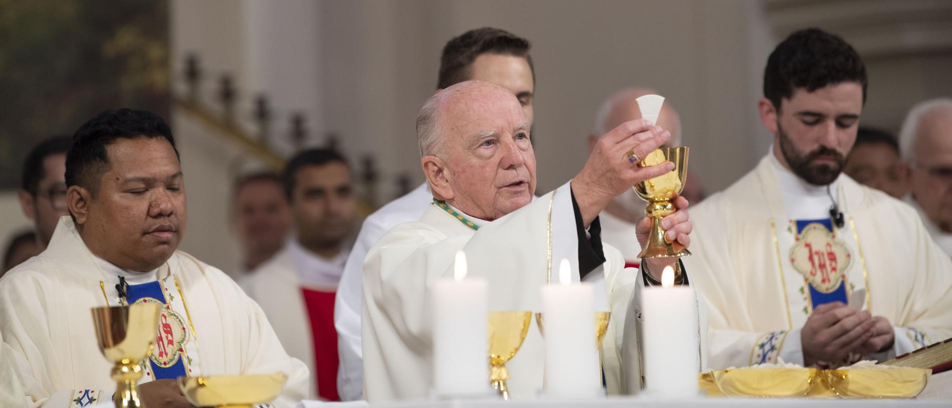 Newly ordained priests Fr Brian Redondo (left) and Fr Nathan Webb assist Bishop Robert McGuckin during the Solemn Mass. Picture: Nev Madsen.