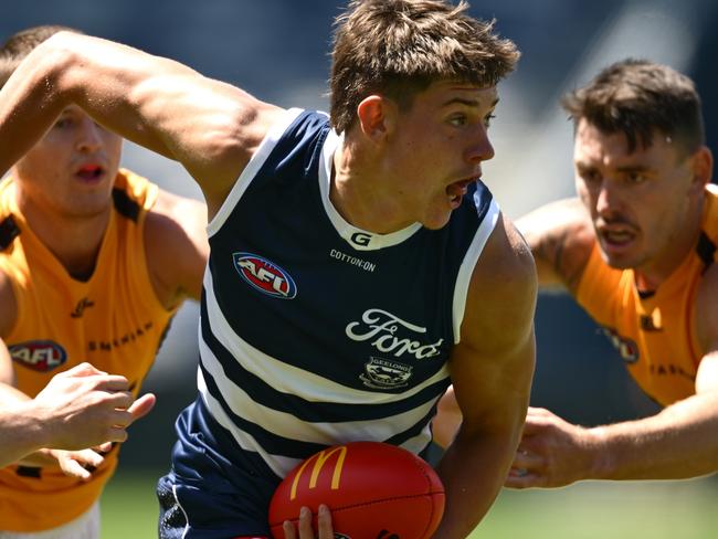 GEELONG, AUSTRALIA - FEBRUARY 17: Connor O'Sullivan of the Cats handballs whilst being tackled during the AFL practice match between Geelong Cats and Hawthorn Hawks at GMHBA Stadium on February 17, 2025 in Geelong, Australia. (Photo by Quinn Rooney/Getty Images)