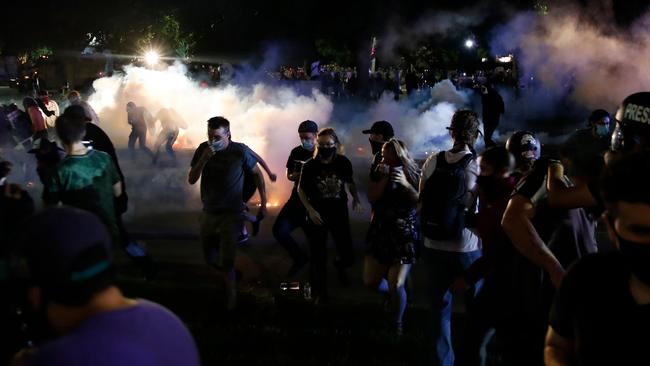 Protestors run for cover as police shoots teargas in an effort to disperse the crowd outside the County Courthouse during demonstrations against the shooting of Jacob Blake in Kenosha, Wisconsin. Picture: Kamil Krzaczynski/AFP