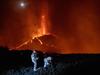 TOPSHOT - In this handout photograph taken and released by the Spanish Military Emergency Unit (UME) on October 16, 2021, members of the GIETMA (Technological and Environmental Emergencies Intervention Group) of the UME monitor the evolution of a new lava flow, following the eruption of the Cumbre Vieja volcano, on the Canary island of La Palma. - There is no prospect of the volcanic eruption in Spain's Canary Islands ending "in the short or medium term", experts said on October 13, 2021 after three-and-a-half weeks of activity. (Photo by Luismi Ortiz / UME / AFP) / RESTRICTED TO EDITORIAL USE - MANDATORY CREDIT "AFP PHOTO / LUISMI ORTIZ  / SPANISH MILITARY UNIT (UME) " - NO MARKETING - NO ADVERTISING CAMPAIGNS - DISTRIBUTED AS A SERVICE TO CLIENTS
