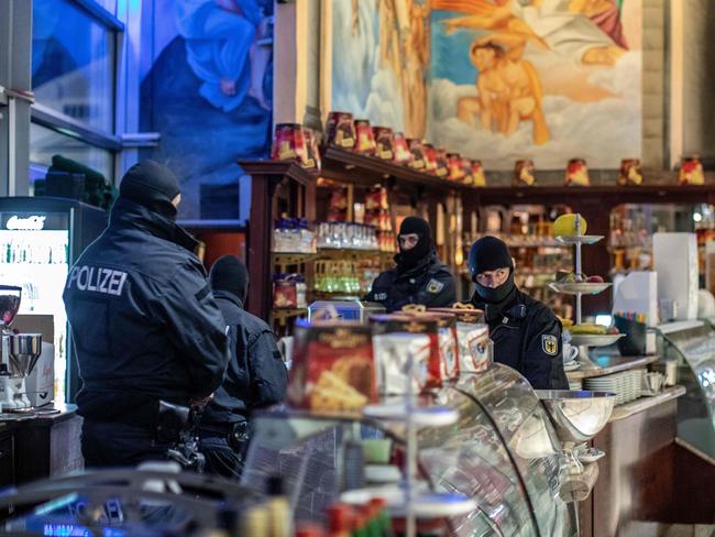 TOPSHOT - Policemen raid an ice cafe in Duisburg, western Germany, on December 5, 2018. - Around 90 people suspected of belonging to the notorious 'Ndrangheta mafia were rounded up in raids across several European and Latin American countries, Italian police said. The suspects are thought to be key members of the powerful organised crime syndicate based in southern Italy. They are accused of committing "serious crimes" including activities linked to international drug trafficking. The vast anti-mafia operation was carried out by Italy's anti-mafia and anti-terrorism force in collaboration with German, Belgian and Dutch authorities. (Photo by Christoph Reichwein / dpa / AFP) / Germany OUT