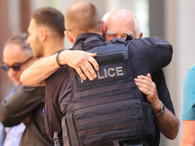 Nino Pangrazio embraces a police officer. Picture: Alex Coppel