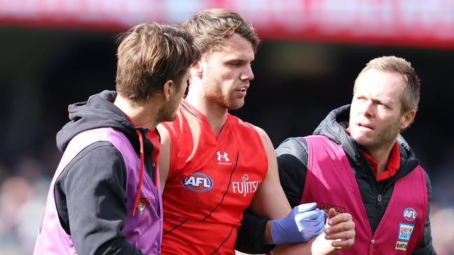 Jordan Ridley in the hands of trainers. Picture: Sarah Reed/AFL Photos via Getty Images