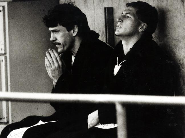 Brian Taylor (left) watches the game from the bench.