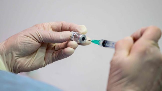 A nurse fills a syringe with the Pfizer Biontech vaccine Comirnaty at the vaccination center of German speciality chemicals company Evonik in Hanau, western Germany, on Mai 19, 2021, amid the ongoing coronavirus (Covid-19) pandemic. (Photo by THOMAS LOHNES / AFP)