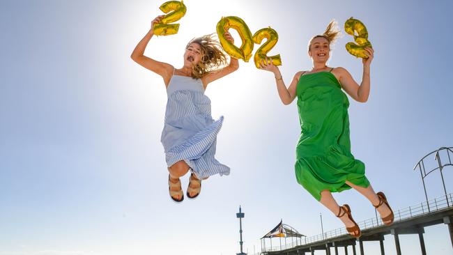 Midwife Lilly Flannagan and psychology graduate Catherine White celebrate 2023 at Brighton Beach. Picture: Brenton Edwards