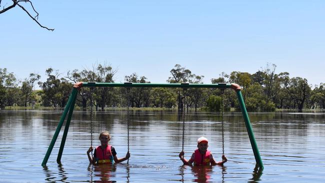 Skye (left) and Chloe Golding enjoy the now underwater swing at Apex Park, in Ramco near Waikerie. Picture: Supplied / Julia Golding