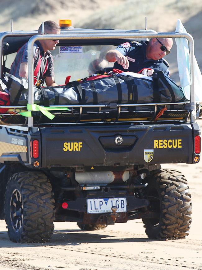 Paramedics take a casualty down the beach to an ambulance in a buggy. Picture: Alan Barber
