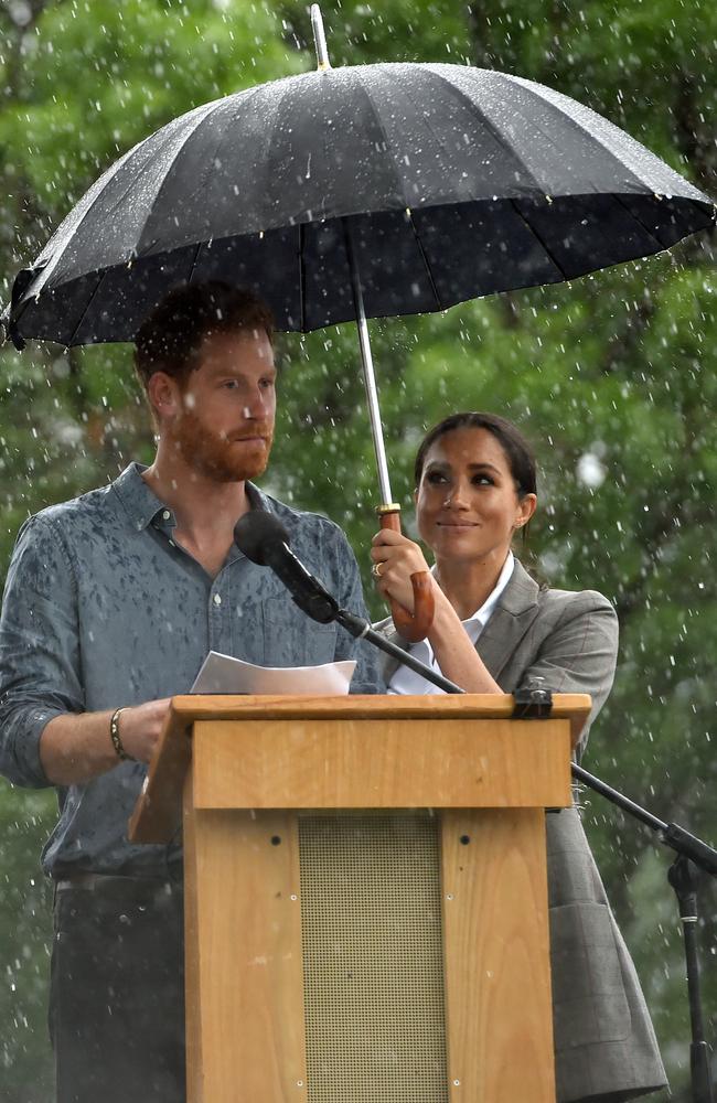 There is again as Meghan shields Harry from the rain. Picture: Peter Parks