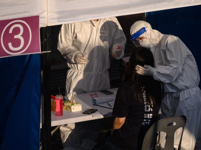 A health worker administers a swab at a temporary COVID-19 novel coronavirus testing centre in Bucheon, south of Seoul. Picture: AFP