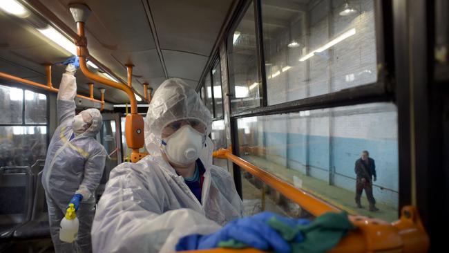 TOPSHOT - Employees wearing protective gear disinfect a tram - as part of preventive measures against the COVID-19 coronavirus - in Saint Petersburg on March 19, 2020. (Photo by OLGA MALTSEVA / AFP)