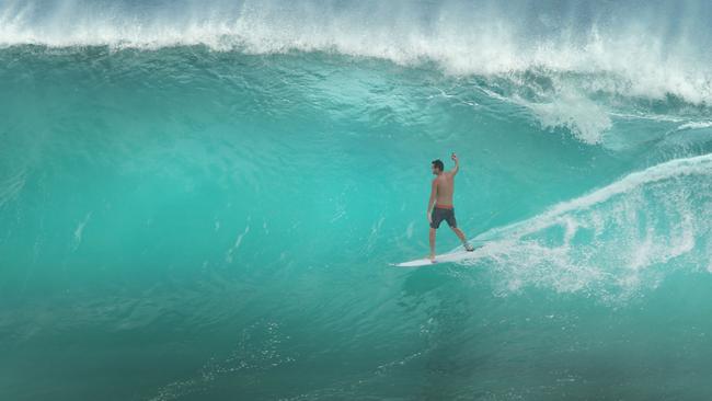 Mad Hueys surfer Dean Harrington films his ride at Kirra during cyclonic swell. Picture: Glenn Hampson