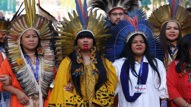 Representatives of indigenous groups from Brazil march through the conference venue on day six of COP28