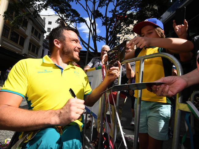 Commonwealth Games wheelchair marathon gold medalist Kurt Fearnley signs autographs during a street parade in Brisbane’s CBD to honour the Games athletes. Picture: Dan Peled/AAP